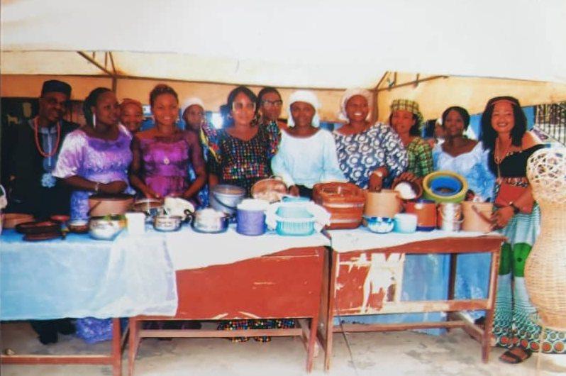 Staff and parents in traditional attire behind a table of local dishes on Cultural Day
