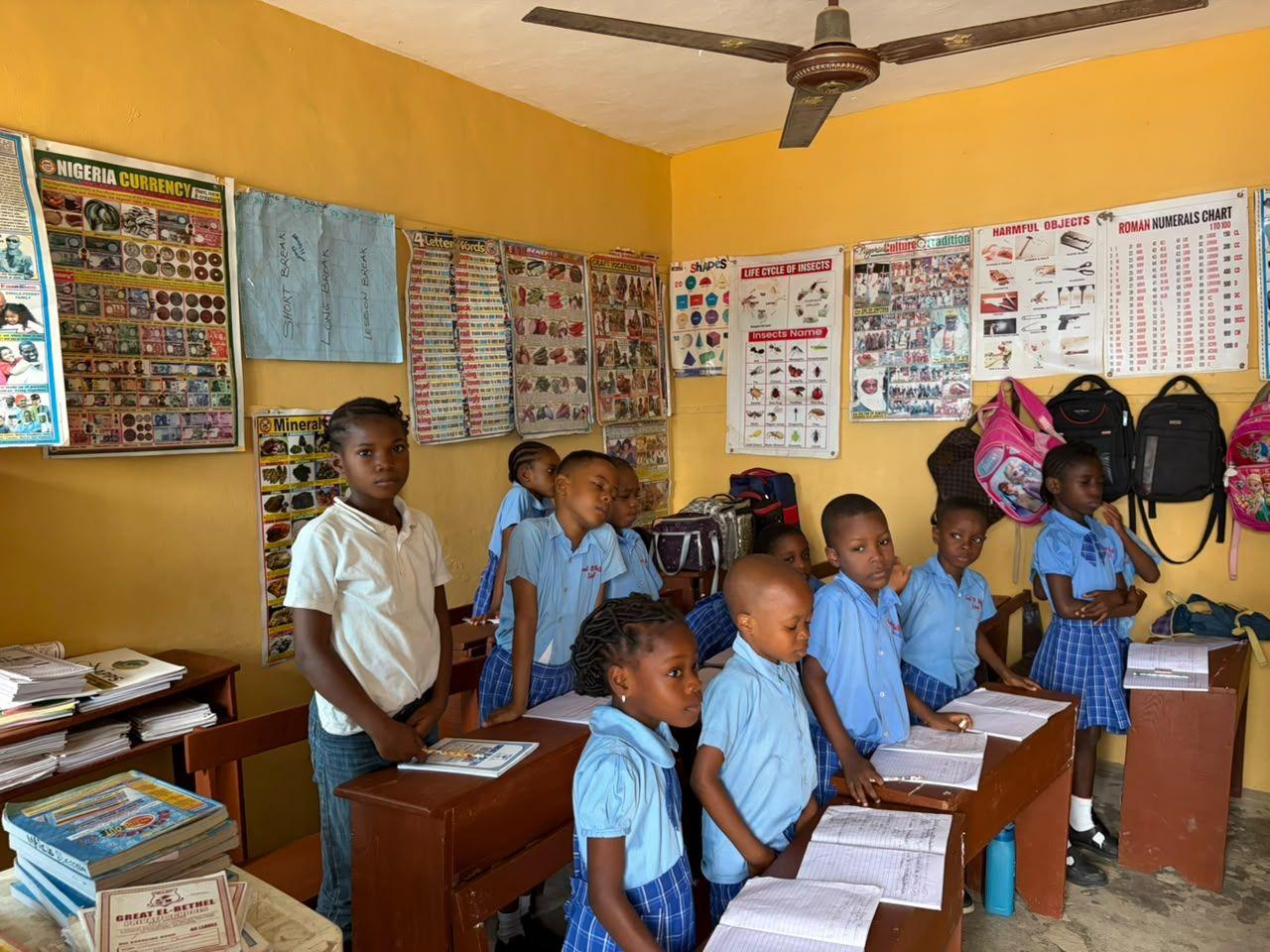 Nursery pupils standing by their desks